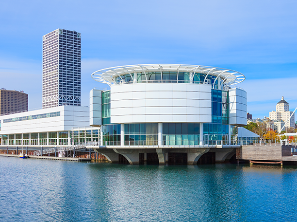 Discovery World’s circular building on Milwaukee’s lakefront with Silver Lakeoffice building rising in the background.